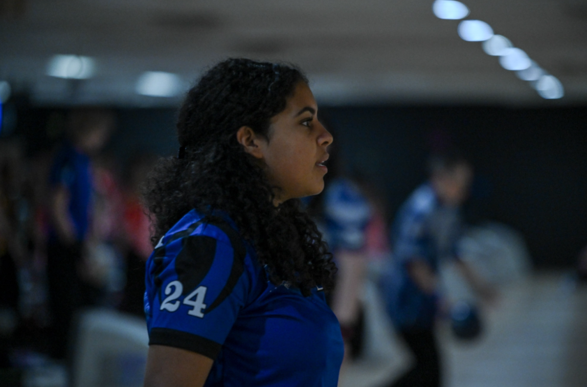 Dee Robinson (11) stays focused and intent as she prepares for her next frame in a fierce bowling match. 